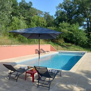 an umbrella and chairs next to a swimming pool at Domaine La Salamandre - Piscine & Forêt privée, Vue sur Vallée in Lauzerte