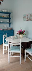a white table and chairs with a vase of flowers at Rose Cottage in Kilrean