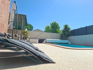 a swimming pool with an umbrella next to a building at La Milhaud in Milhaud