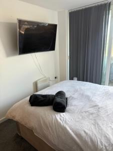 a bedroom with a large bed with a flat screen tv on the wall at Elysium pro in Bradford
