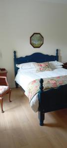 a bedroom with a bed with a blue bed frame at Rose Cottage in Kilrean