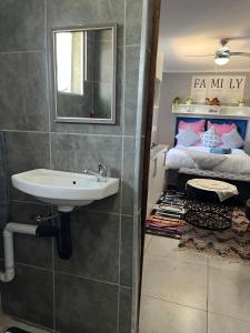 a bathroom with a sink and a bed at Peace House in Pietermaritzburg