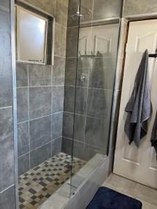 a bathroom with a shower with a glass door at Peace House in Pietermaritzburg