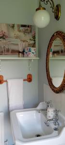 a white bathroom with a sink and a mirror at Rose Cottage in Kilrean +11 photos