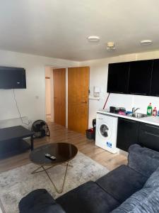 a living room with a couch and a table at Elysium pro in Bradford