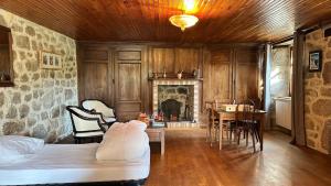 a bedroom with a bed and a table and a fireplace at Le Gite de la Ferme d Issac in Le Nayrac