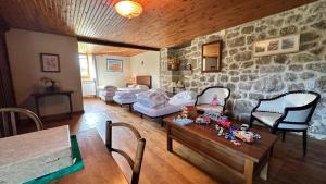 a living room with a stone wall at Le Gite de la Ferme d Issac in Le Nayrac