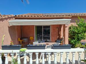 a patio with chairs and an awning on a house at La Milhaud in Milhaud