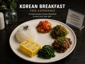 a plate of food with rice and vegetables on a table at Friendly DH Naissance Hotel by Mindrum Group in Seoul