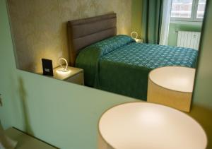 a small bedroom with a bed and a mirror at Casa Thaila - Box auto gratuito in Milan