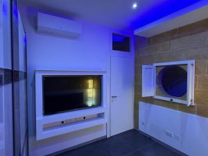 a room with a television and a wall with blue lights at Cardinal Rooftop Townhouse by Aureum in Birgu