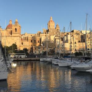 a group of boats docked in a marina with a building at Cardinal Rooftop Townhouse by Aureum in Birgu