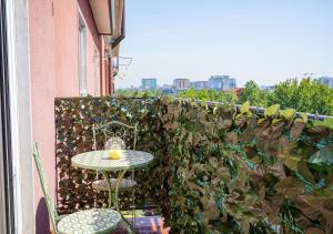 a table and chairs on a balcony with a green wall at Casa Thaila - Box auto gratuito in Milan