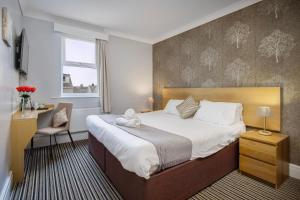 a bedroom with a bed with a teddy bear on it at Ashley Victoria in Blackpool