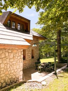 a stone house with a picnic table in the yard at Green Forest in Žabljak