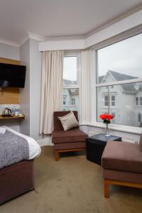 a bedroom with a bed and a chair and a window at Ashley Victoria in Blackpool