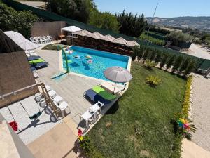 an overhead view of a swimming pool with chairs and an umbrella at Casa Alfio in Centobuchi