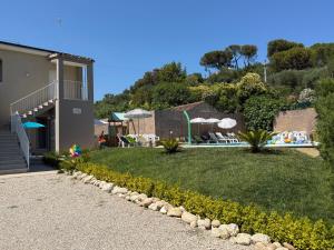 a lawn with chairs and umbrellas in a yard at Casa Alfio in Centobuchi