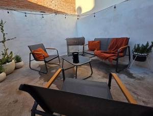 eine Terrasse mit zwei Stühlen, einer Couch und einem Tisch in der Unterkunft GARÍ Loft in Chihuahua