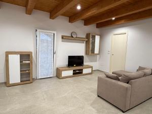 a living room with a couch and a tv at Casa Alfio in Centobuchi