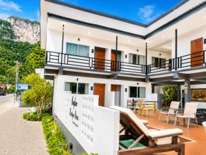 a house with a balcony with chairs and tables at Nangkam Boutique House in Ko Phi