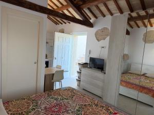 a bedroom with a bed and a desk with a television at Casa Alfio in Centobuchi +49 photos
