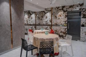 a dining room with a table with chairs and a refrigerator at The Bay Suites - Salt Lake in kolkata
