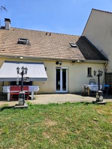 a house with a picnic table in front of it at Maison Romantique entre deux fleuves chez l'habitant in Montereau-Fault-Yonne