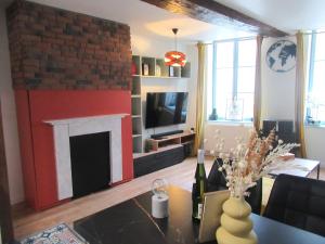 a living room with a fireplace and a table at Vue magnifique sur le Château fort, dans le centre historique in Sedan