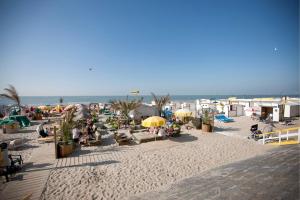 a beach with chairs and umbrellas and the ocean at Holiday Suites Blankenberge in Blankenberge