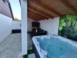 a hot tub on the patio of a house at Panoráma Vendégház Jásd in Jásd