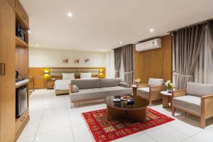 a living room with a couch and a bed at Hotel Excelsior Karachi in Karachi