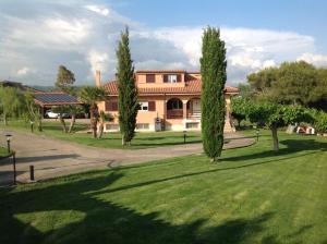 a large house with trees in front of a lawn at Bed & Breakfast La Volpe e L'Uva in Santa Marinella