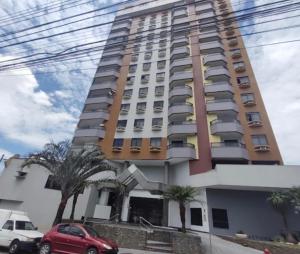a tall building with cars parked in front of it at Apartamento, Campos dos Goytacazes, centro in Campos dos Goytacazes