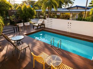 a pool on a deck with chairs and a table at Nangkam Boutique House in Ko Phi