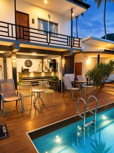 a villa with a swimming pool and a house at Nangkam Boutique House in Ko Phi