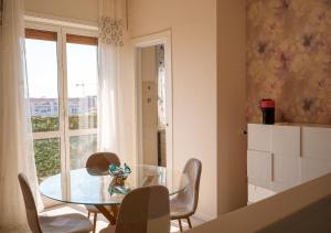 a dining room with a glass table and chairs at Casa Thaila - Box auto gratuito in Milan