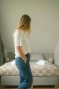 a woman walking in front of a bed at Raduńskie Zacisze in Chmielno