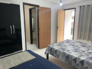 a bedroom with a bed and a door to a hallway at Pousada Recanto Penedo in Penedo