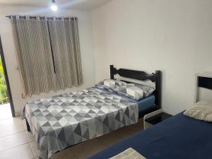 a bedroom with two beds and a window at Pousada Recanto Penedo in Penedo