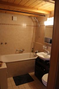 a bathroom with a tub and a sink and a toilet at El Balcón des Diablerets in Les Diablerets +42 photos