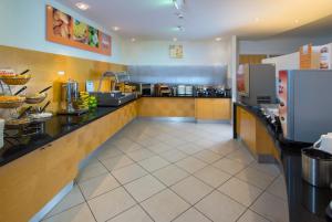 a large kitchen with a counter in a restaurant at Holiday Inn Express Bedford by IHG in Bedford