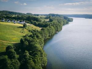 an aerial view of a river with houses and trees at Raduńskie Zacisze in Chmielno
