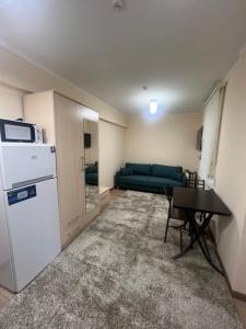 a small living room with a refrigerator and a table at Radugawest2 in Koshkolʼ +13 photos