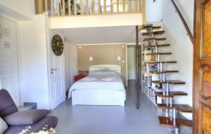 a bedroom with a bed and a spiral staircase at Chez Laurence et Thomas in Cercié
