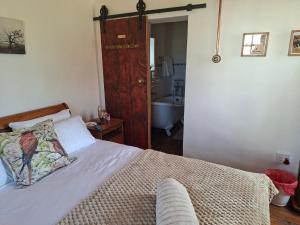 ein Schlafzimmer mit Bett und ein Badezimmer mit Badewanne in der Unterkunft Van Wyks Hartshuis in Sutherland