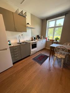 a kitchen with a table and a refrigerator and a dining room at Stationshuset i Immeln in Immeln +12 photos
