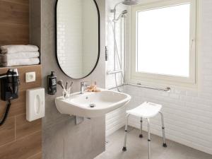 a bathroom with a sink and a mirror and a stool at ibis Antwerpen Centrum in Antwerp