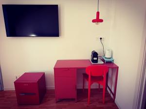 a red desk with a red chair in a room at Studio64 in Civitavecchia