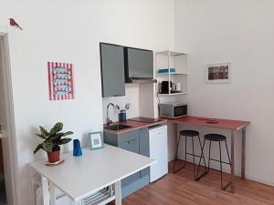 a small kitchen with a counter and a table at Studio64 in Civitavecchia